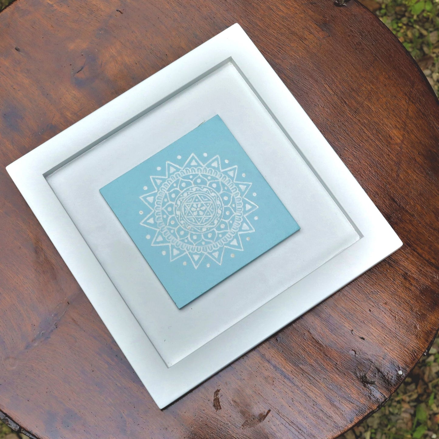 Blue And White Colored Hand Painted Kumouni Aipan Inspired Wall Decor in White MDF Frame.