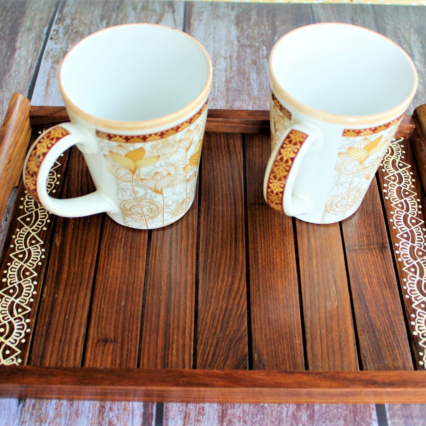 This is beautifully hand painted wooden serving tray for homes. The painting in the centre is inspired by traditional aipan art of kumoun region of rural Uttarakhand.