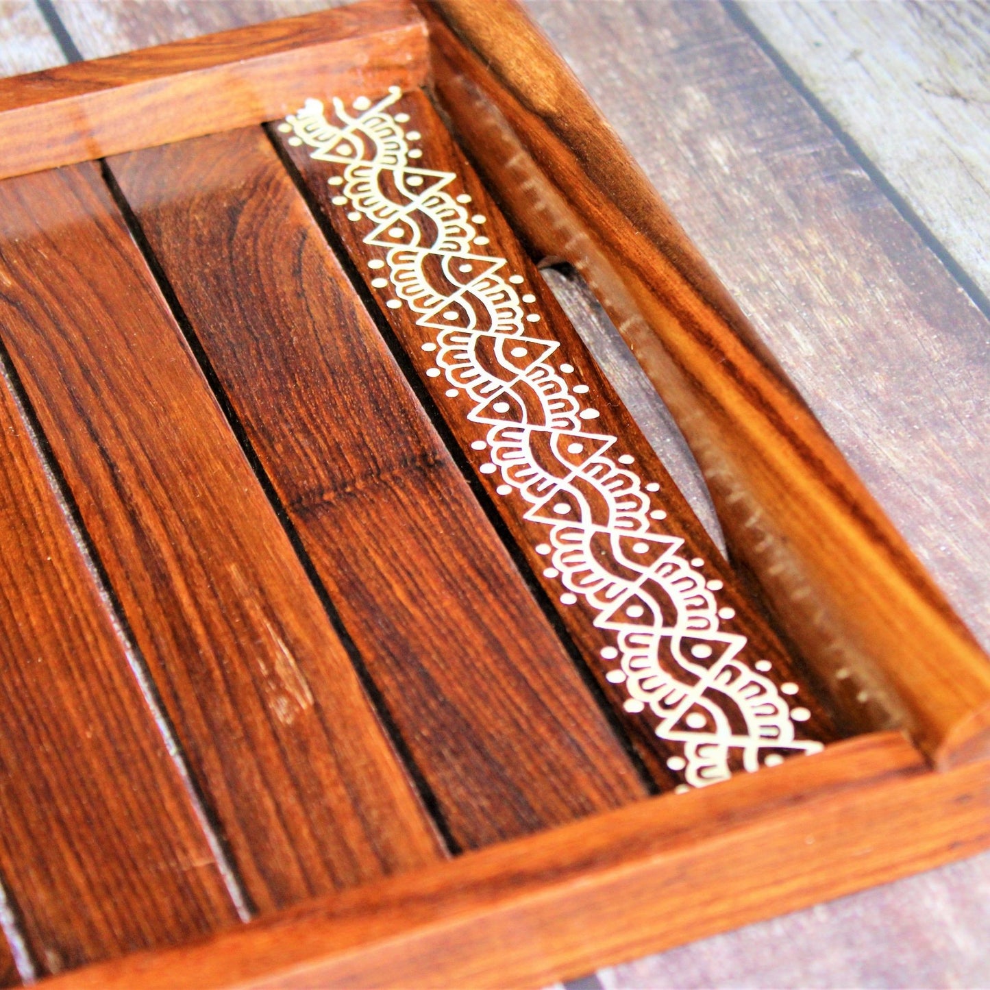 This is beautifully hand painted wooden serving tray for homes. The painting in the centre is inspired by traditional aipan art of kumoun region of rural Uttarakhand.