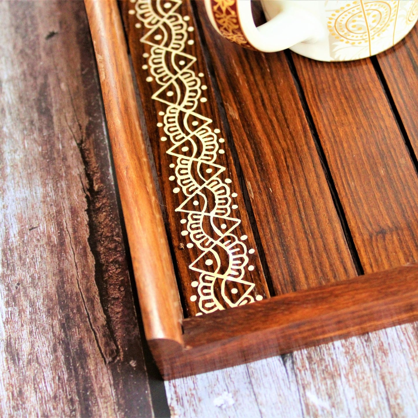 This is beautifully hand painted wooden serving tray for homes. The painting in the centre is inspired by traditional aipan art of kumoun region of rural Uttarakhand.