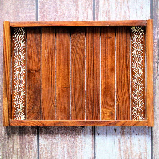 This is beautifully hand painted wooden serving tray for homes. The painting in the centre is inspired by traditional aipan art of kumoun region of rural Uttarakhand.