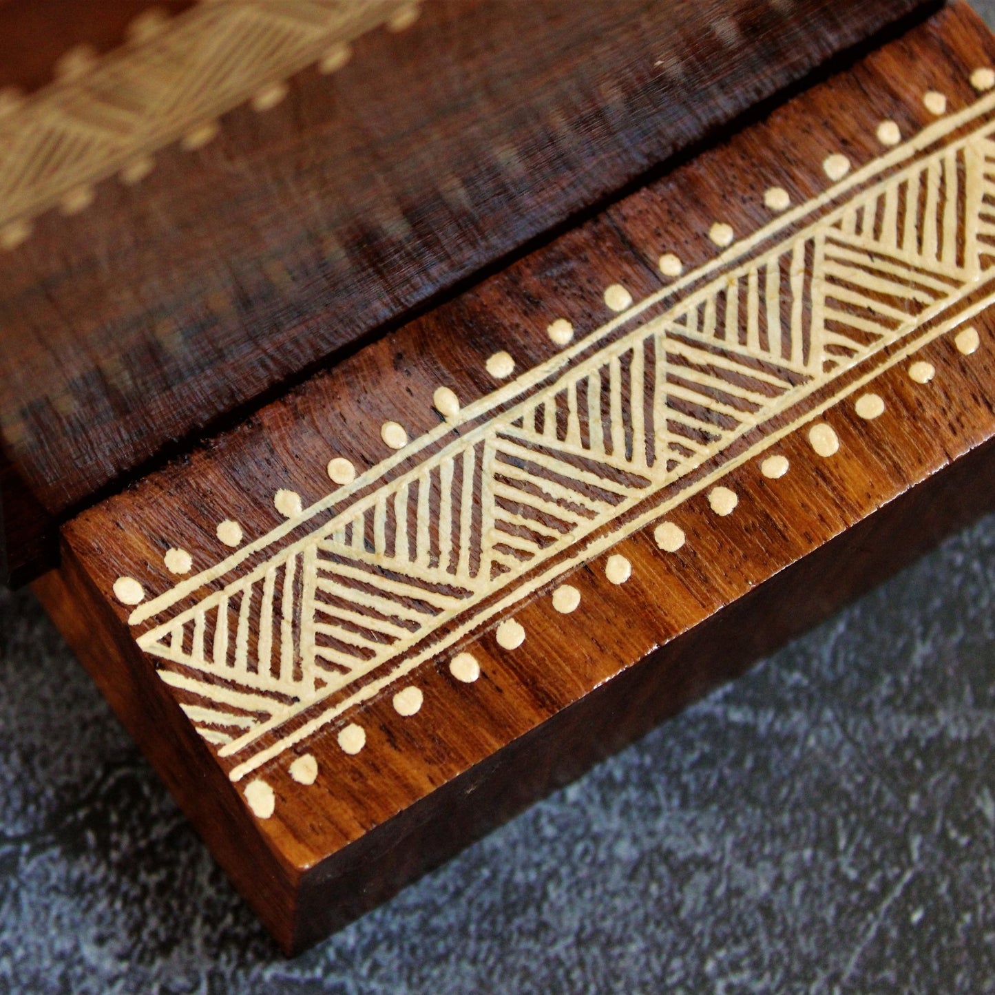 Indian Rosewood Hand Painted and Well Finished Coaster Set with Stand. It is a set of four coasters with hand painted aipan inspired design on them.