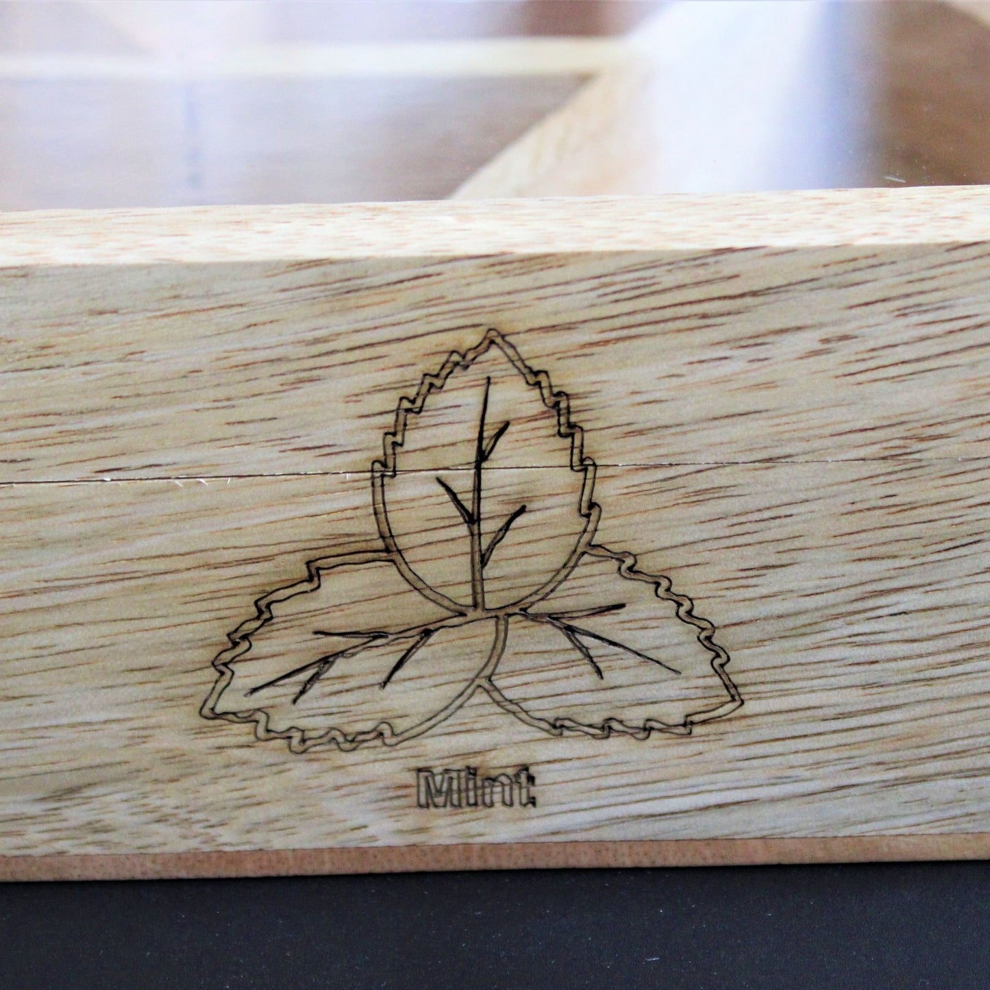 Spicy Bite Engraved Mango Wood Masala Dani or Indian Spice box with seven partitions in hexagon shape. This one shows the laser engraving done on the sides of the box.