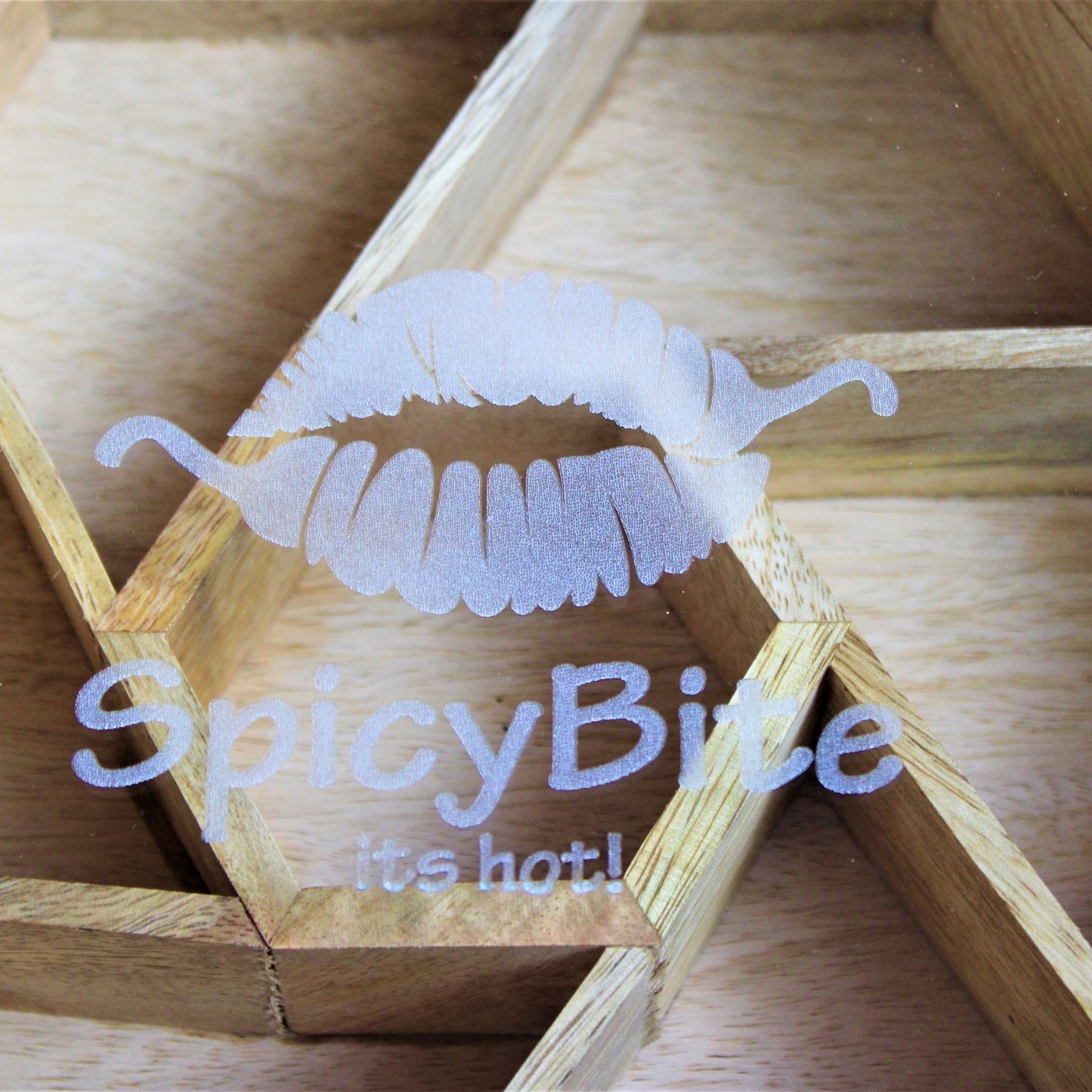 Spicy Bite Engraved Mango Wood Masala Dani or Indian Spice box with seven partitions in hexagon shape. This one shows the laser engraving done on the glass.