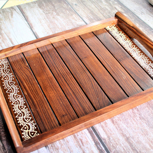 This is beautifully hand painted wooden serving tray for homes. The painting in the centre is inspired by traditional aipan art of kumoun region of rural Uttarakhand.
